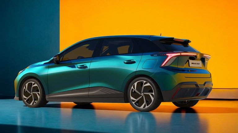 Green modern hatchback car shown from the rear side in a studio setting.